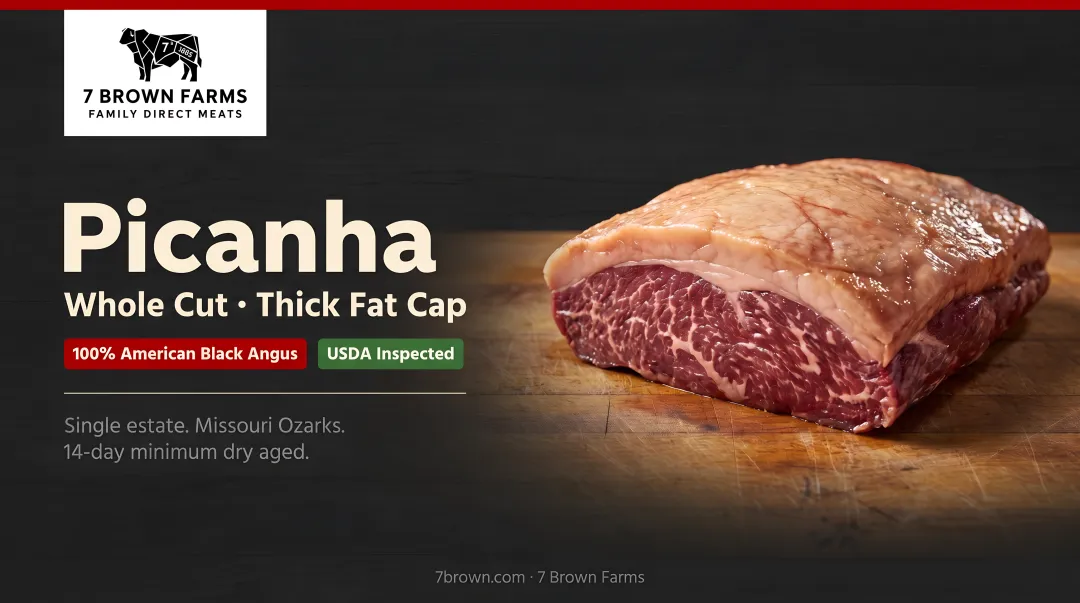 Well-marbled whole picanha cut with thick intact fat cap on butcher block