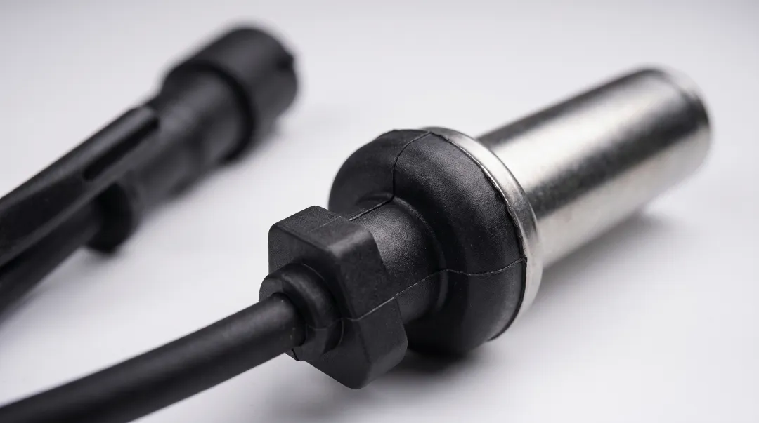Automotive wheel speed sensor with overmolded TPU housing and cable assembly