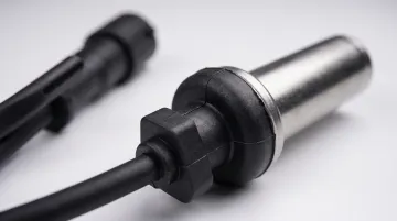 Automotive wheel speed sensor with overmolded TPU housing and cable assembly