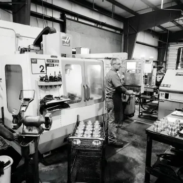 CNC machining specialist operating precision milling equipment in a manufacturing facility