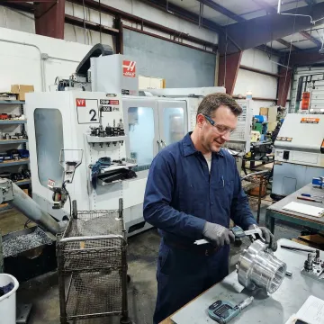 Machinist reviewing precision part dimensions at a CNC workstation