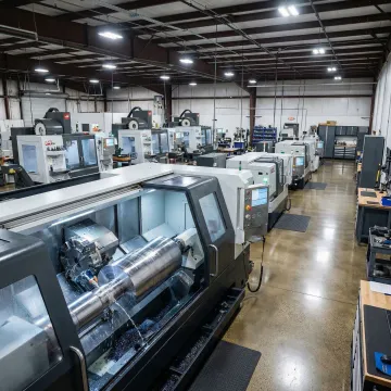 Large CNC turning machine producing a precision-turned metal component in a manufacturing facility
