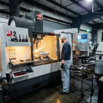 Precision CNC milling machine cutting a metal component in a manufacturing facility