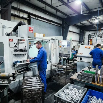 Industrial manufacturing floor with CNC machines and precision machining equipment in operation