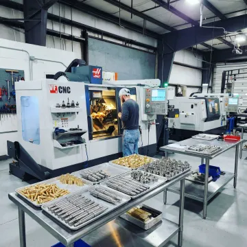 Precision screw machine shop floor with CNC equipment and machined metal parts