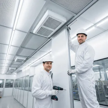 Modular cleanroom components being assembled in controlled environment