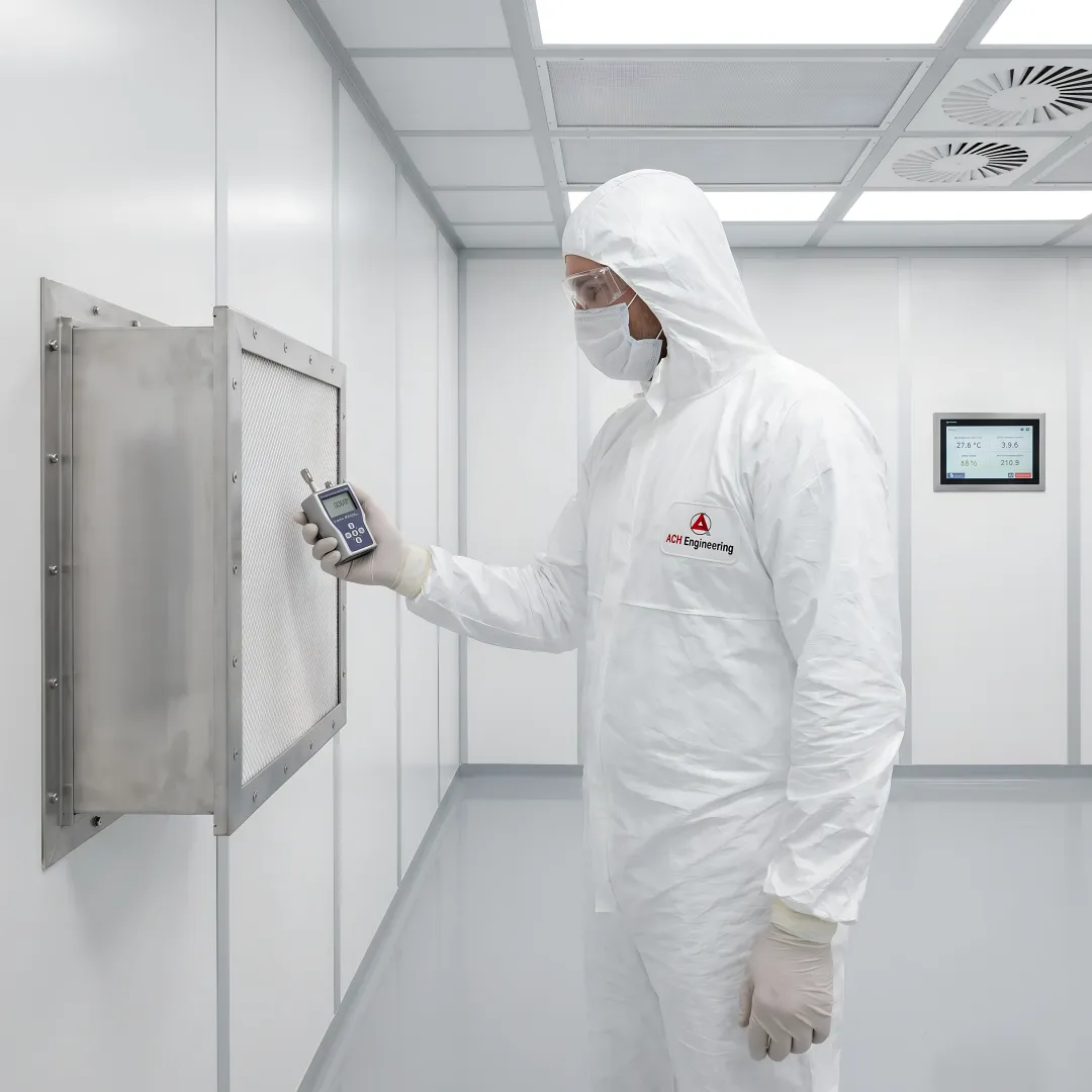 Cleanroom technician performing maintenance and inspection on HEPA filtration system in controlled environment