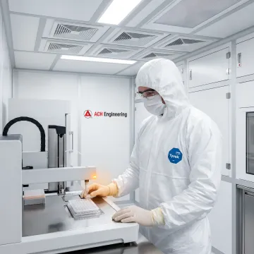 Pharmaceutical researcher working in cleanroom with automated screening equipment