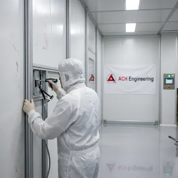 Technician installing modular cold room panels with temperature monitoring equipment