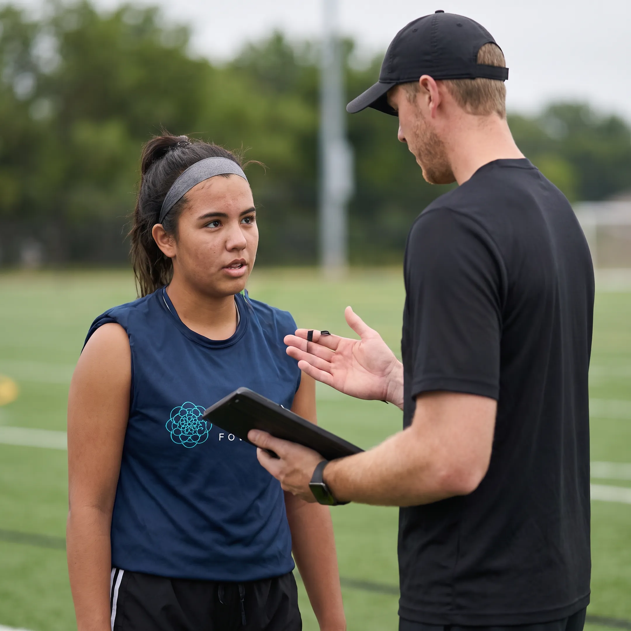 Youth soccer player training with a specialized coach on a field