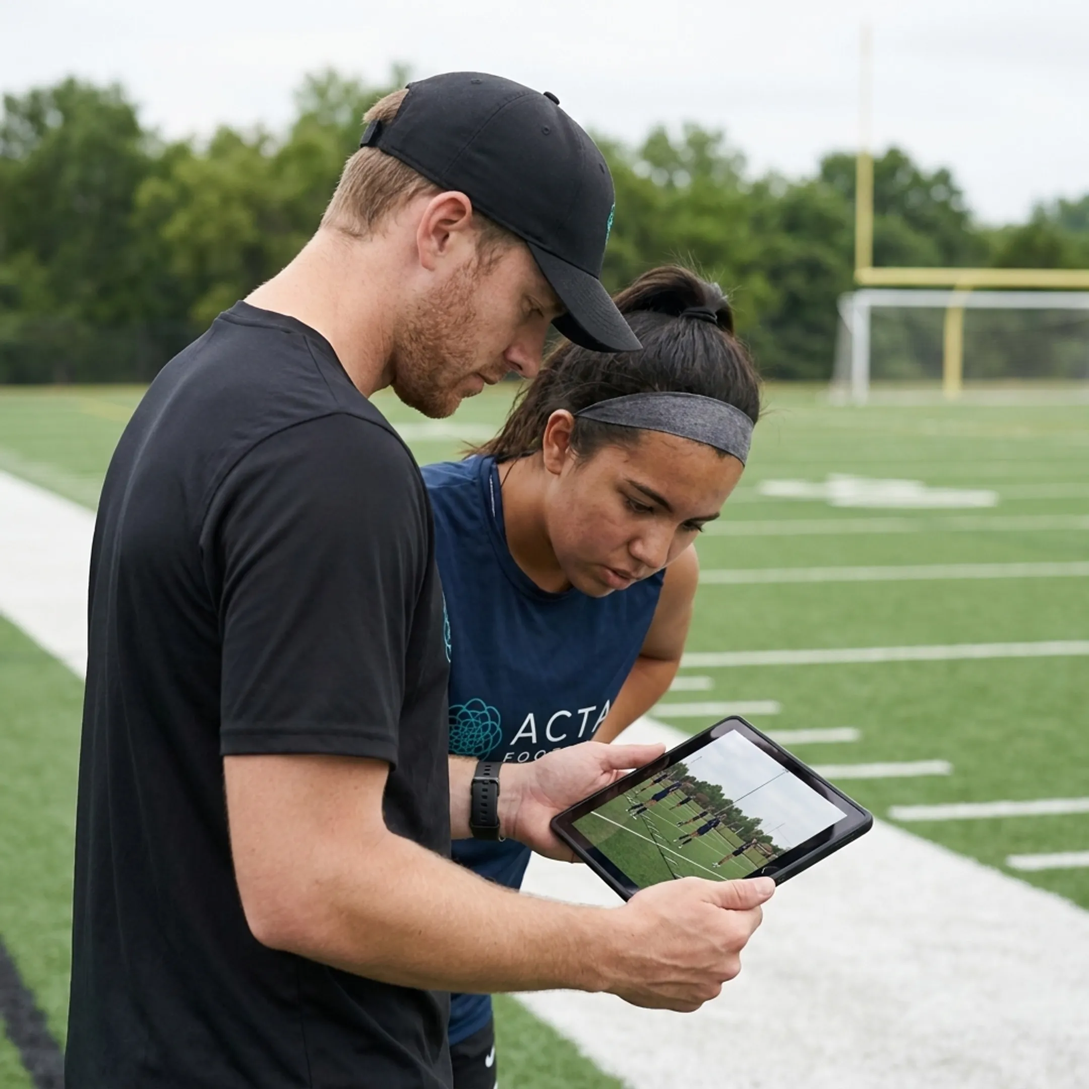 Soccer coach reviewing tactical match film with a competitive youth athlete