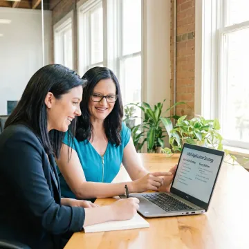 MBA consultant guiding a young applicant through application steps on a laptop
