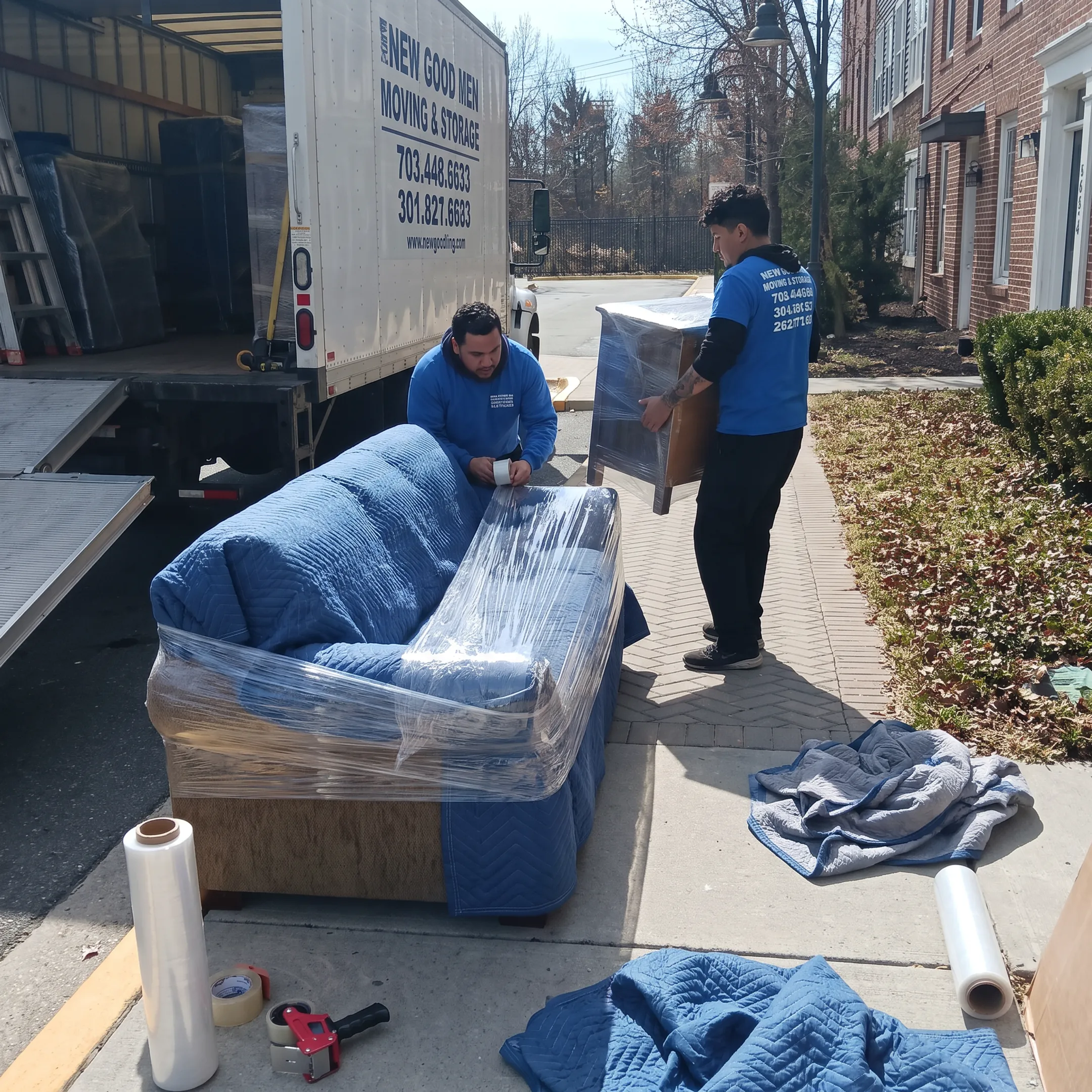 Movers protecting furniture before transport