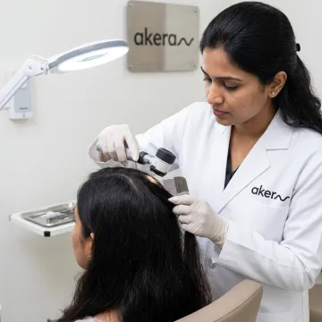 Dermatologist assessing scalp for hair loss treatment