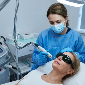 Dermatologist performing laser toning facial treatment