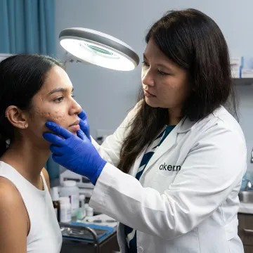 Dermatologist assessing skin before laser treatment