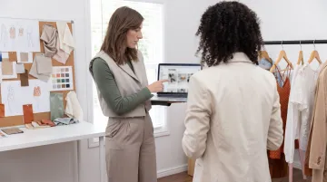 Fashion consultant reviewing client wardrobe portfolio in professional setting