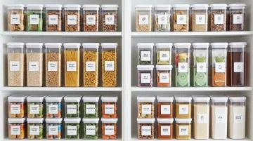 Uniform clear storage containers organized on pantry shelving system