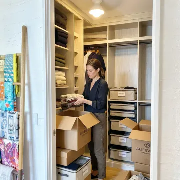 Professional organizer unpacking and arranging a luxury home closet