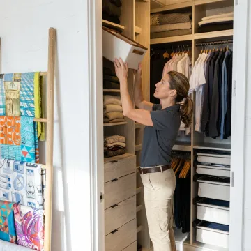 Luxury professional organizer arranging a bright NYC apartment closet