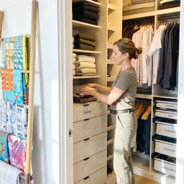 Organized luxury home closet with labeled bins and folded clothing