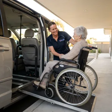 Professional medical transport specialist assisting senior citizen with care and respect
