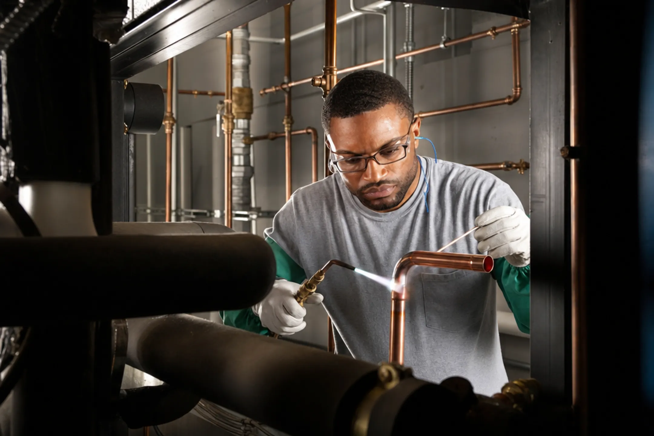 Certified brazer joining copper medical gas piping in facility
