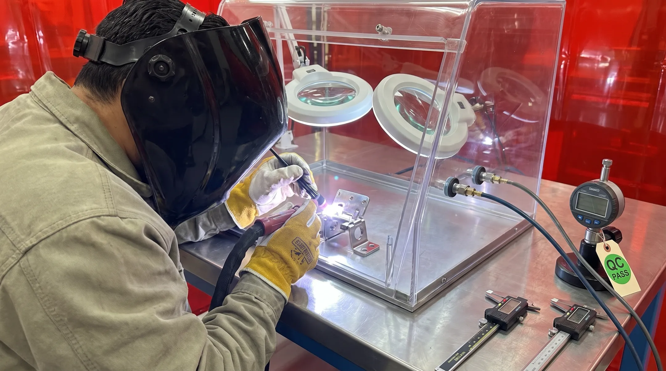 Technician welding exotic alloy aerospace components in fabrication facility