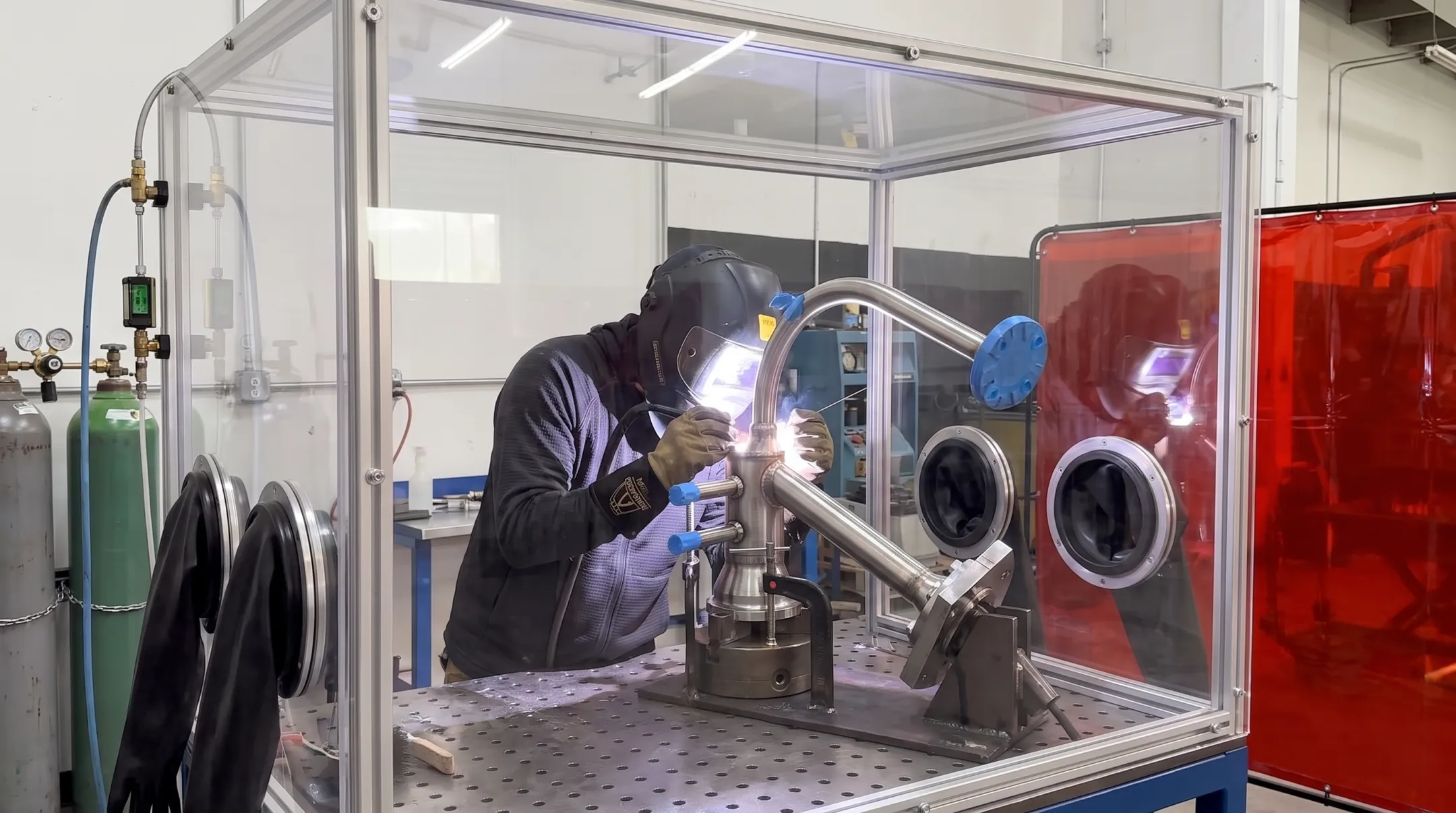 Fabrication shop welding titanium piping inside inert gas chamber