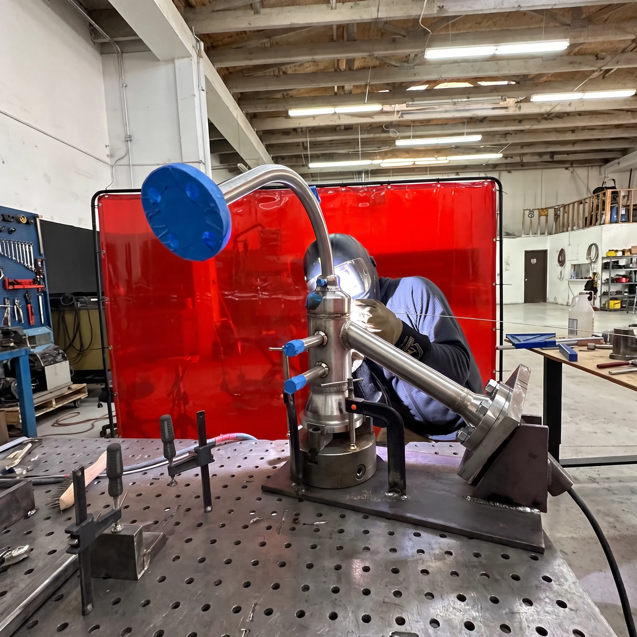 Welder performing precision alloy welding in a controlled fabrication workspace
