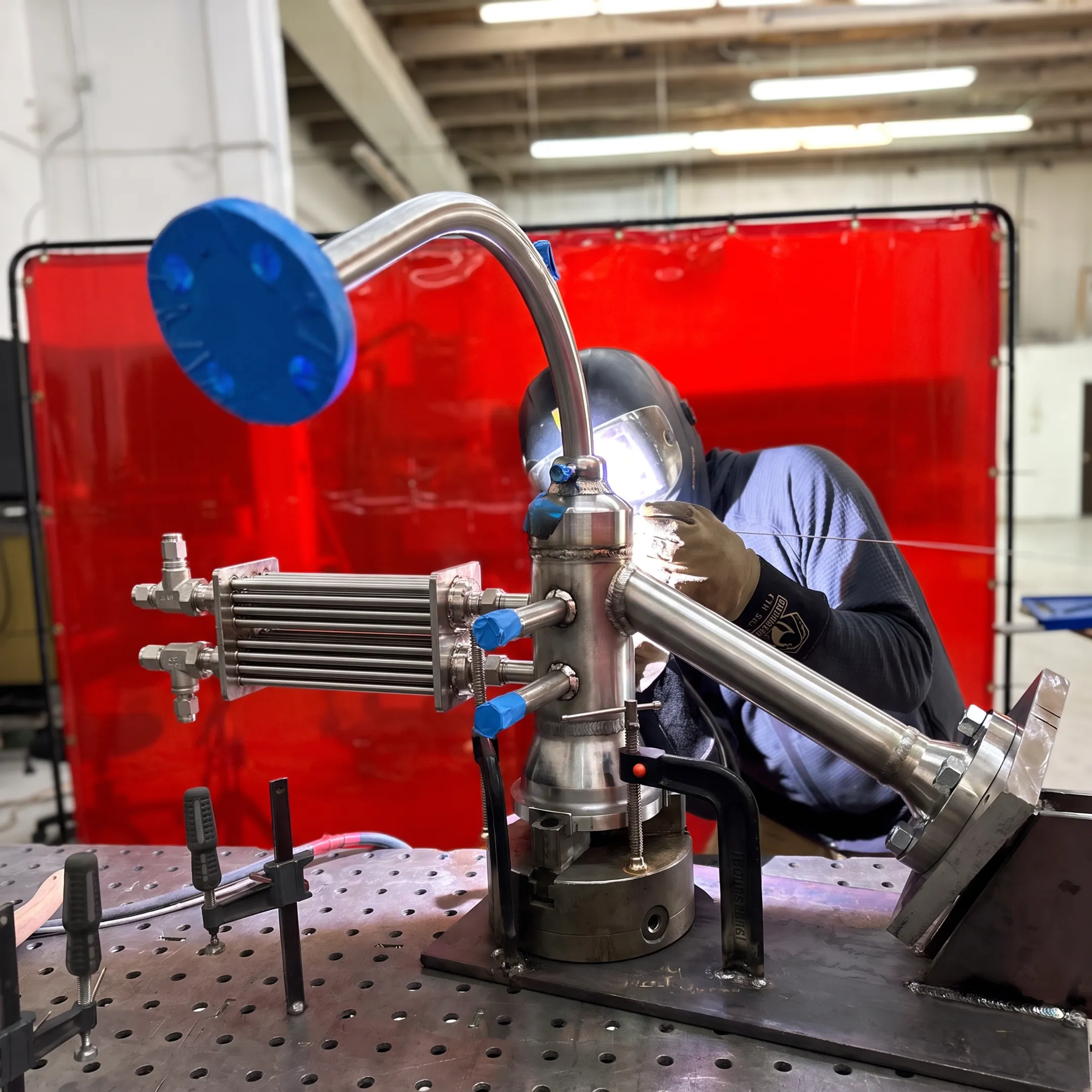 Fabricator welding a precision cryogenic heat exchanger assembly