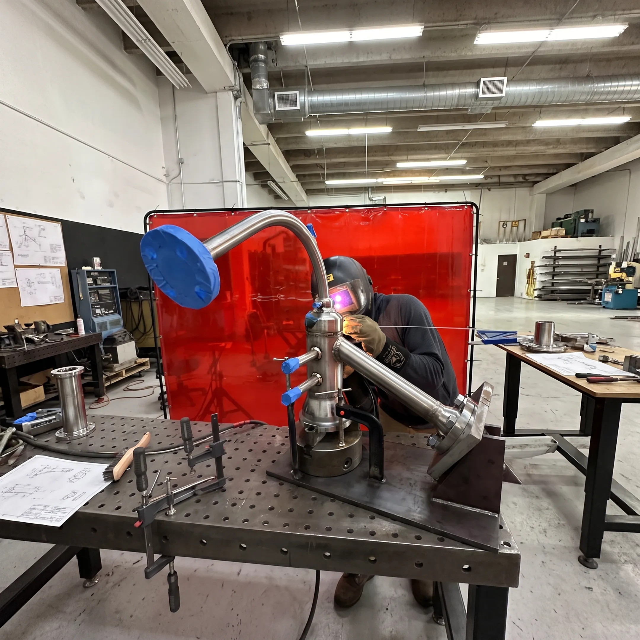 Technician fabricating a custom metal tool in a precision welding shop