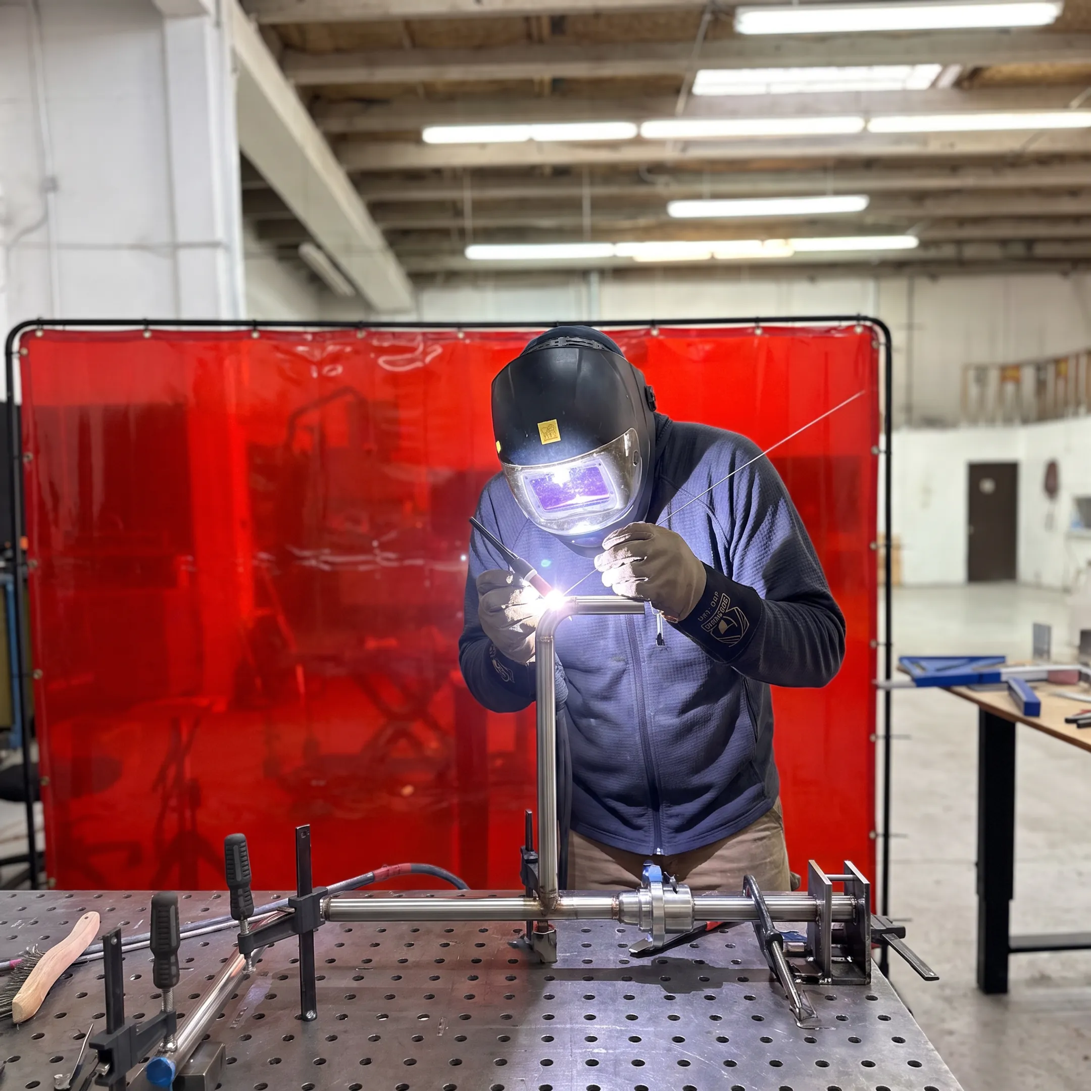Welder fabricating a precision custom tube assembly