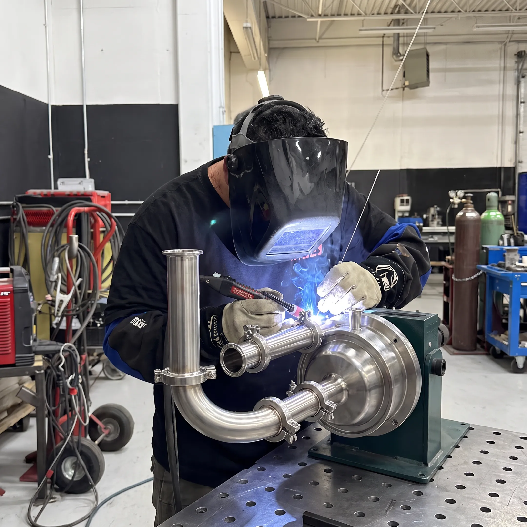 Stainless steel food processing equipment being precision welded in a fabrication shop