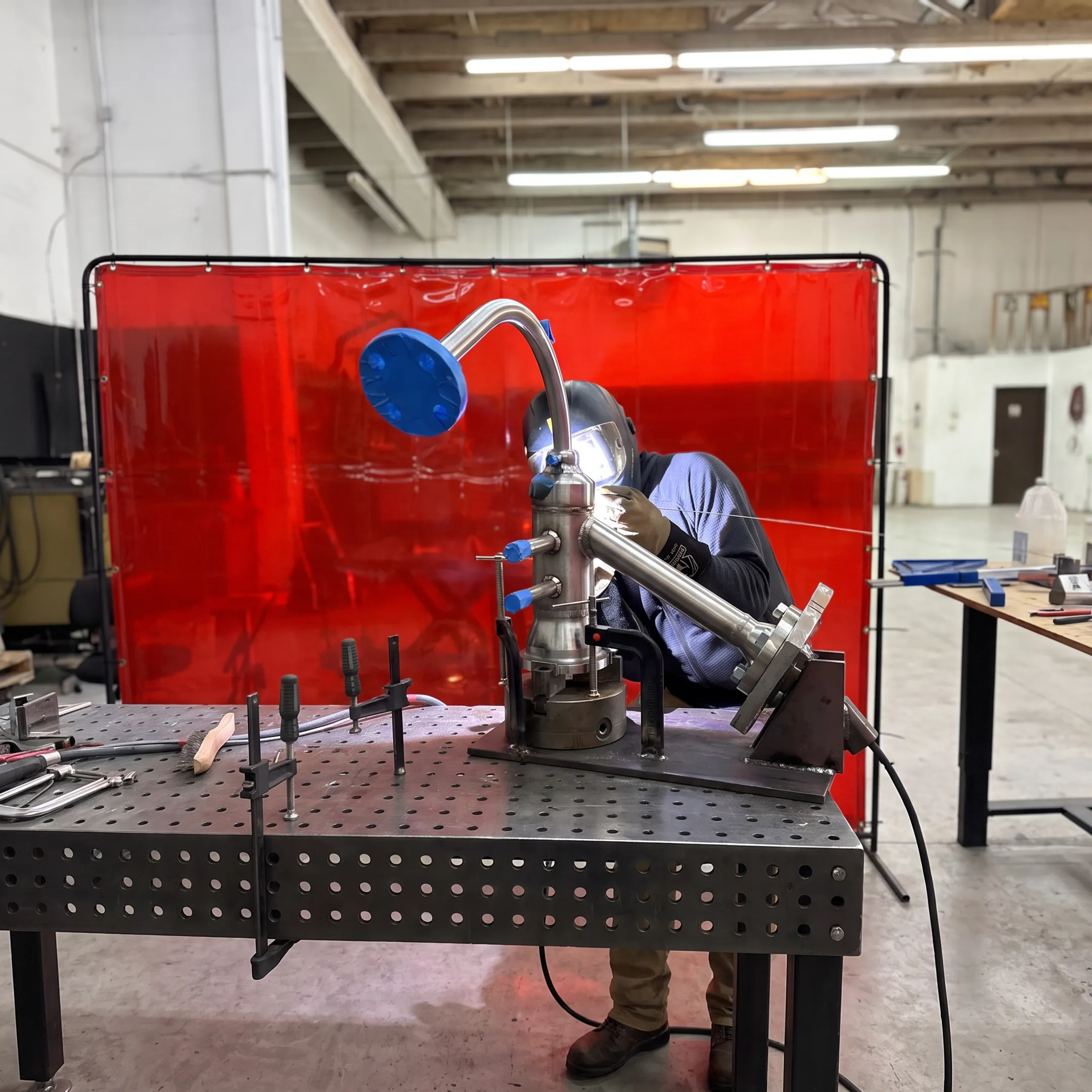 Welder fabricating a precision metal assembly in a specialized shop