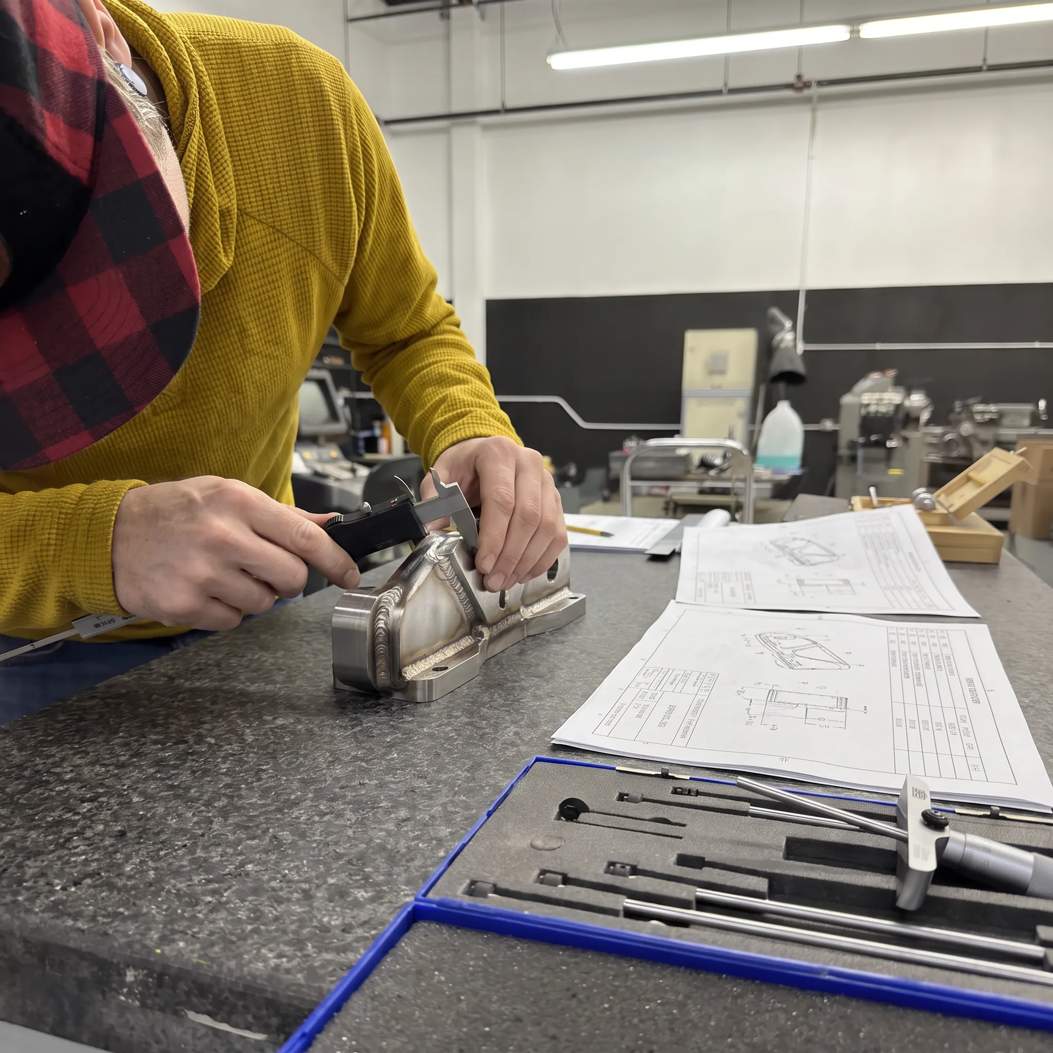 Technician inspecting a precision welded metal component
