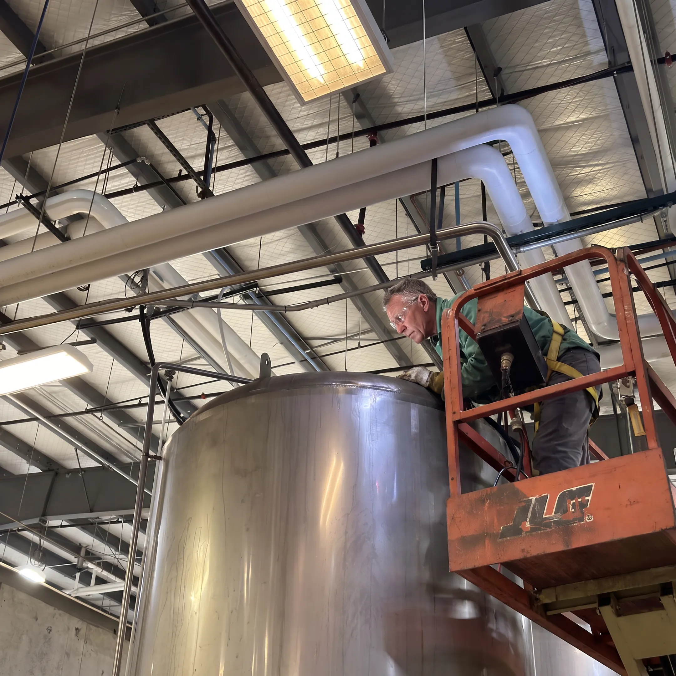 Technician inspecting a custom welded steel tank assembly