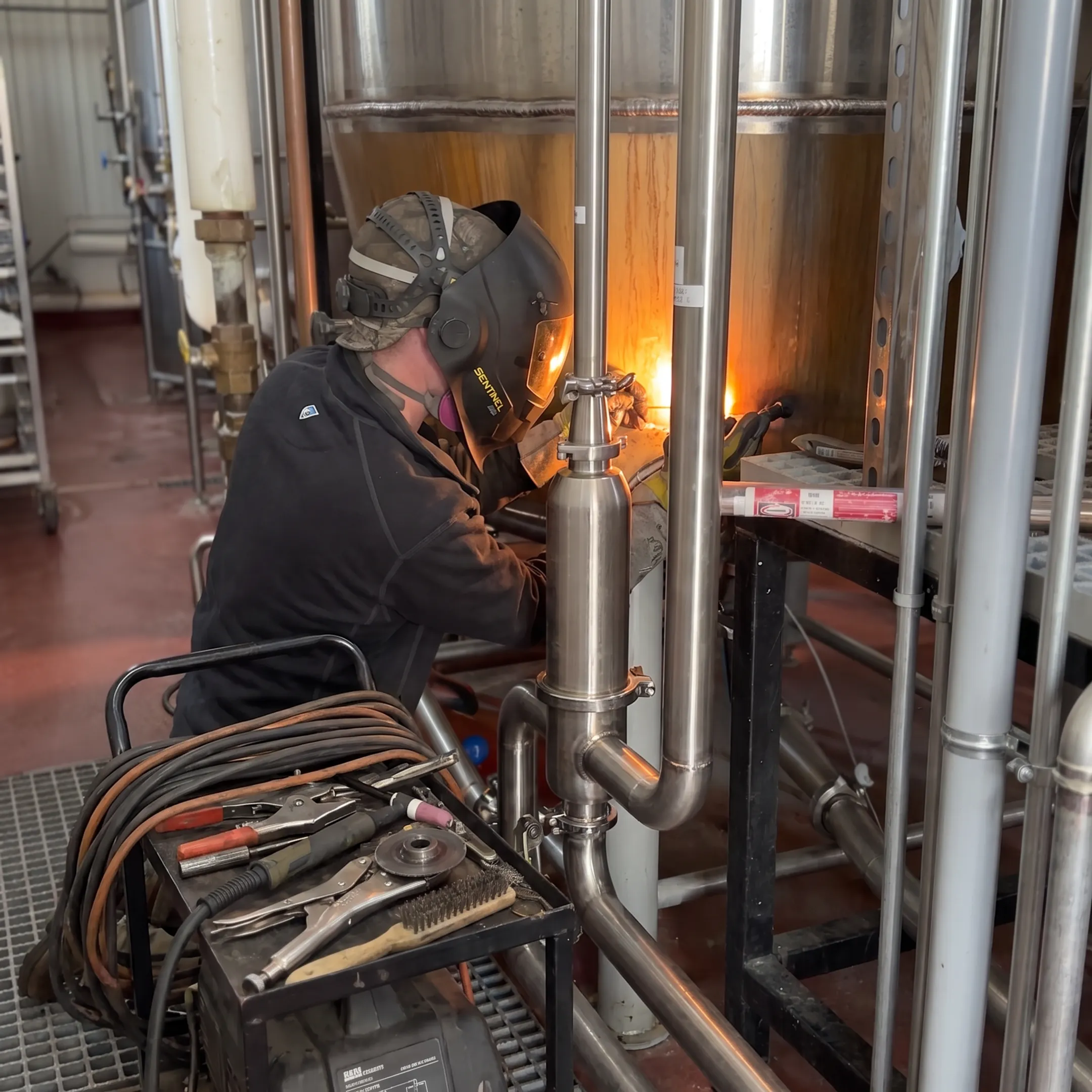 Welder performing precision mobile welding on stainless steel equipment