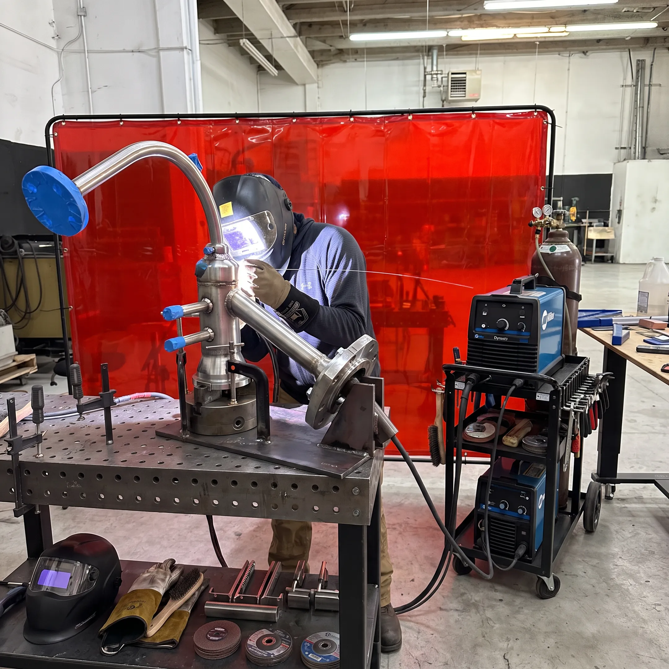 Welder performing precision mobile fabrication on a stainless steel assembly
