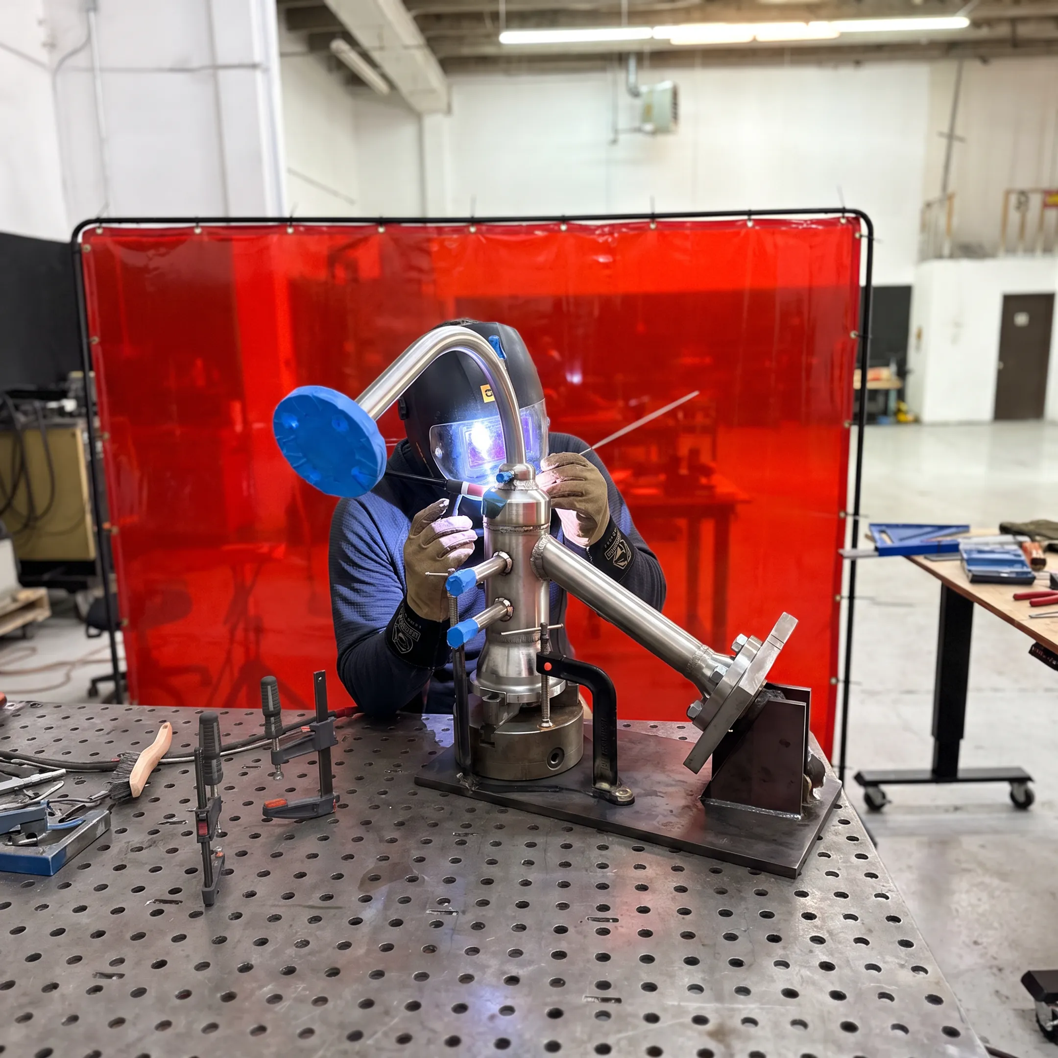 Welder fabricating a precision metal assembly in a professional workshop