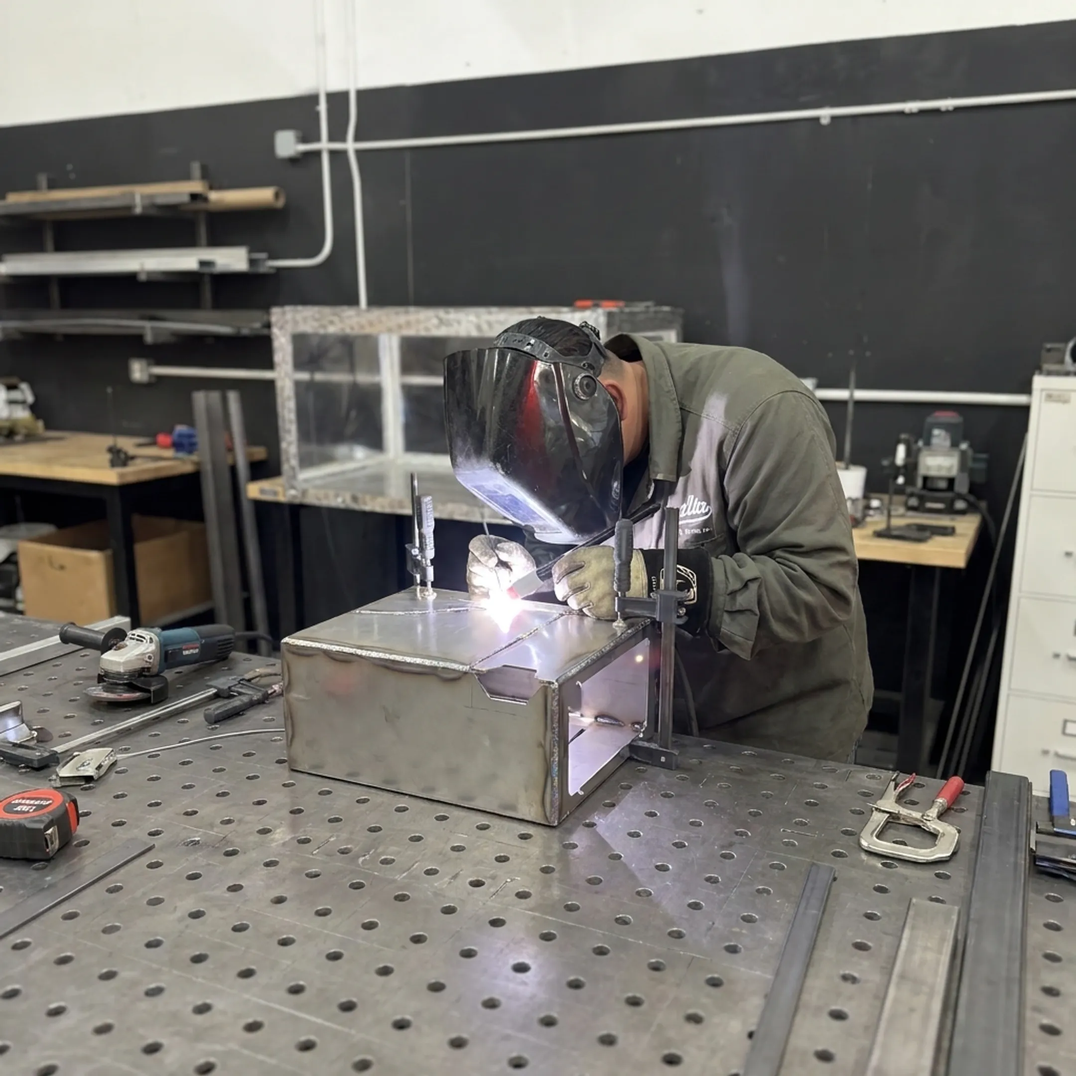 Welder assembling a custom precision sheet metal enclosure