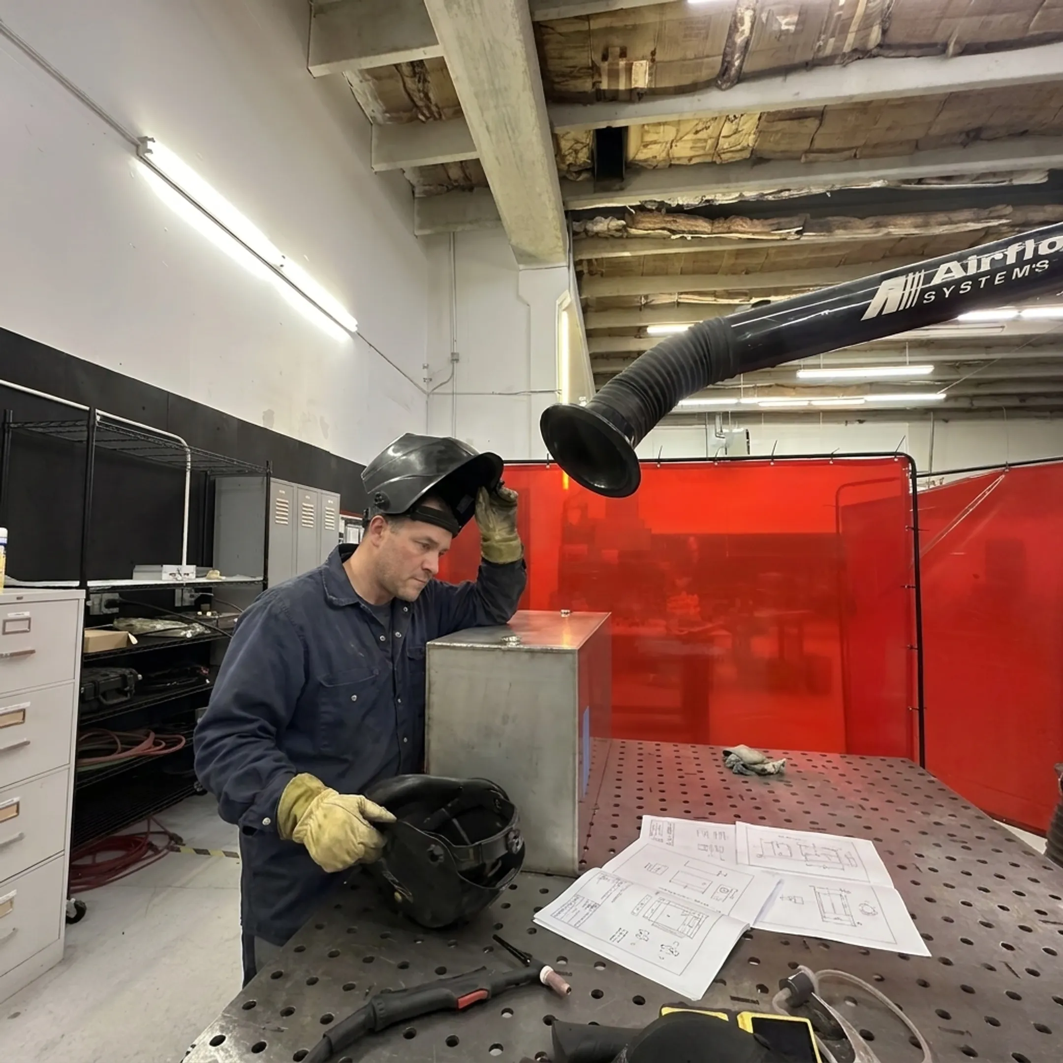 Technician inspecting a precision welded metal assembly