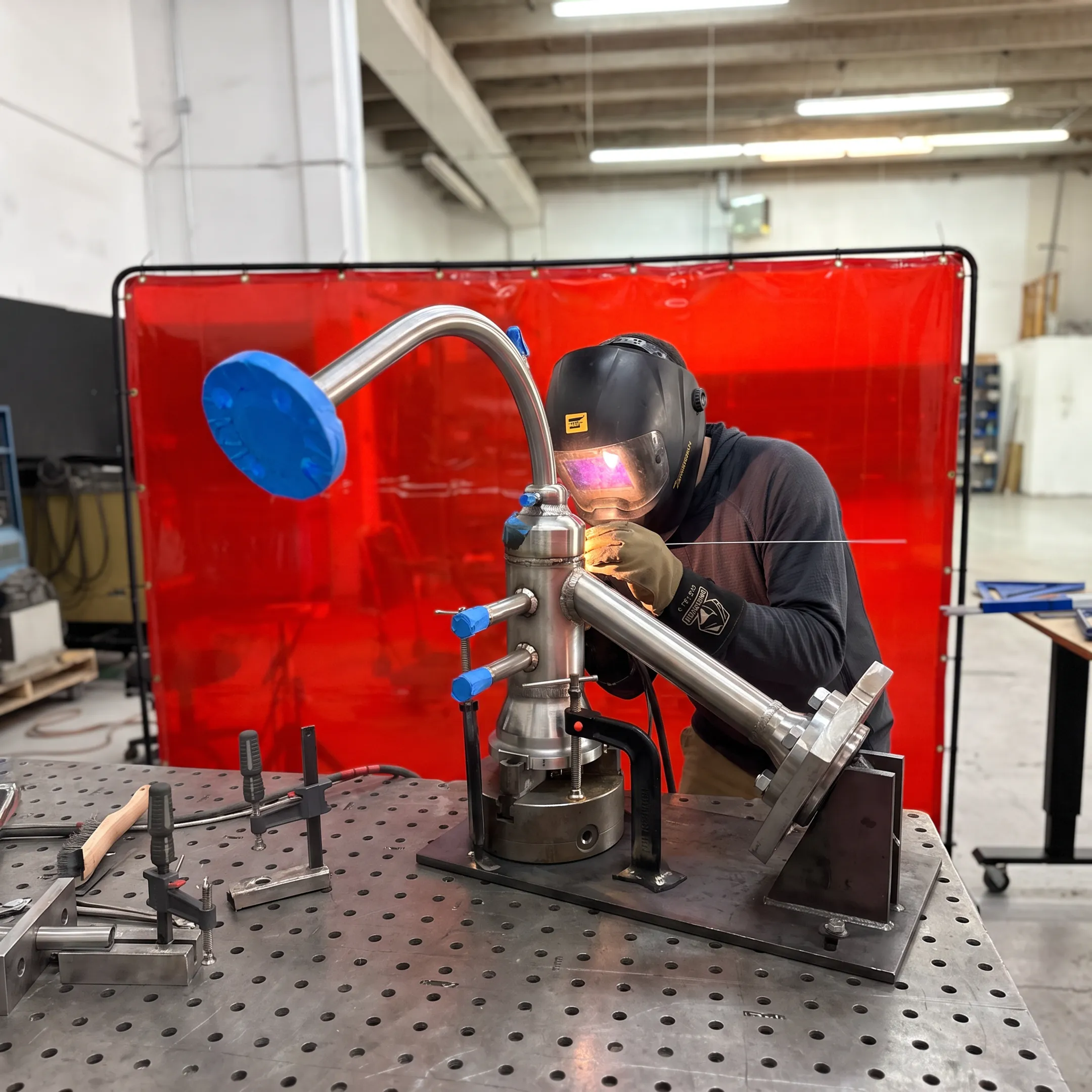 Technician welding a precision industrial metal assembly