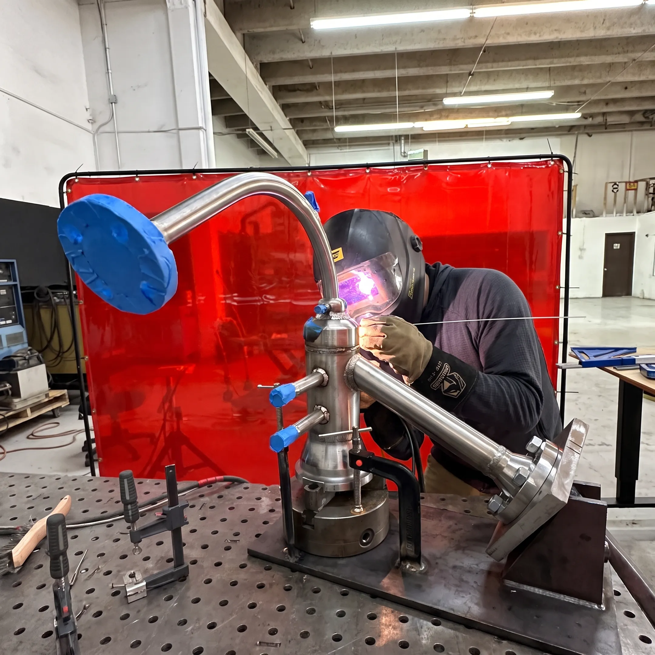 Welder fabricating a precision metal assembly in a professional workshop