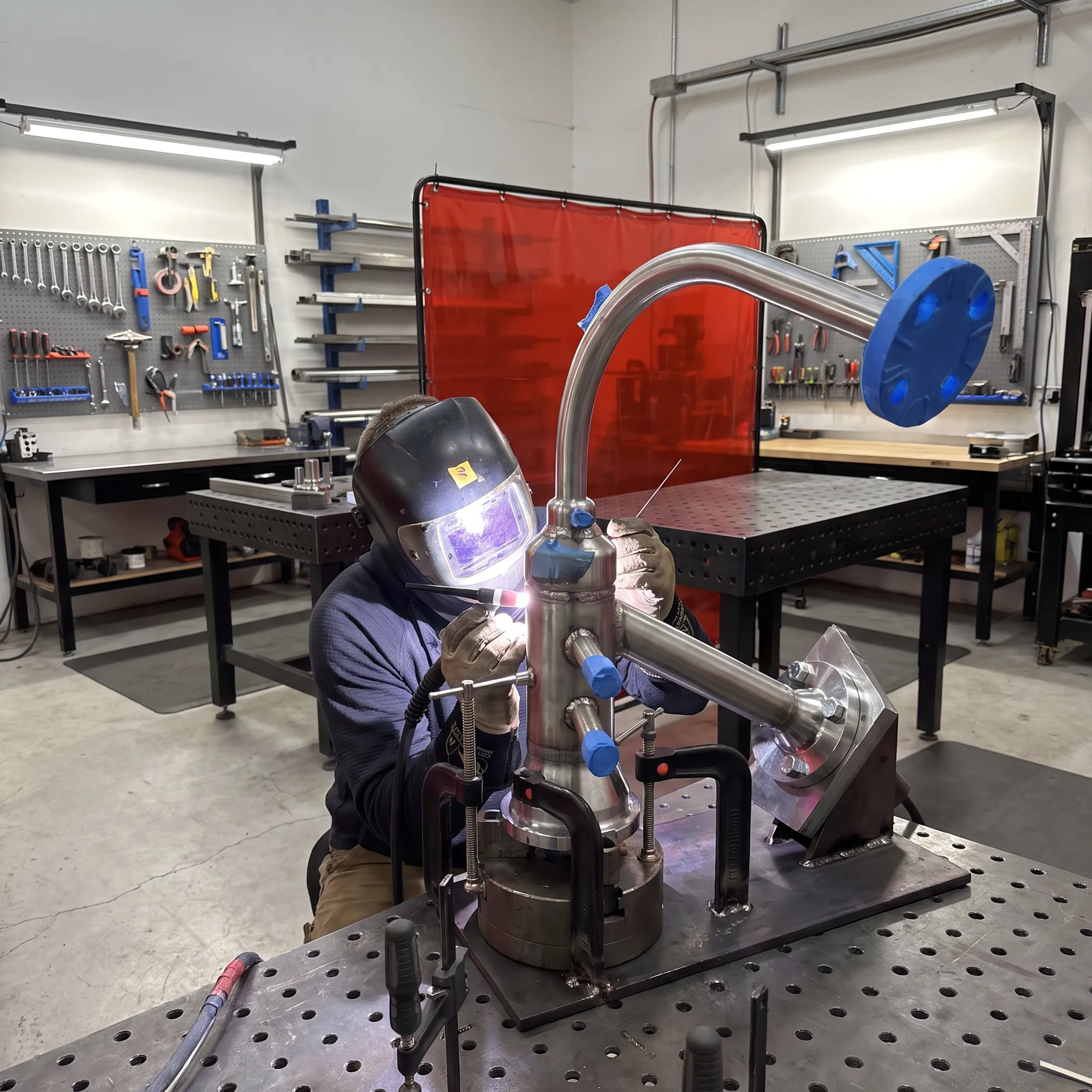 Welder fabricating a stainless steel assembly in a precision fabrication shop
