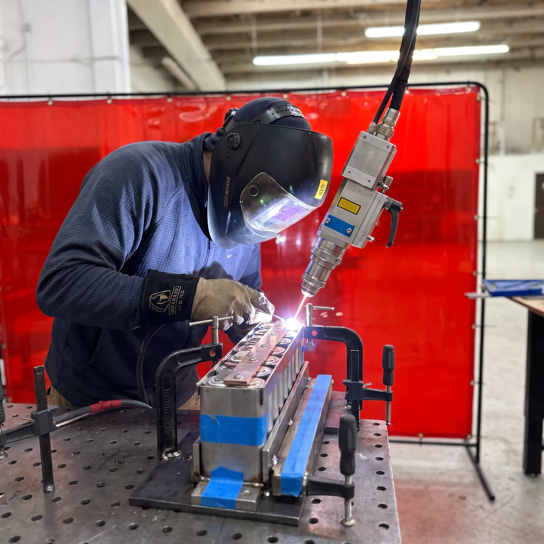Technician operating a laser welding system for battery components