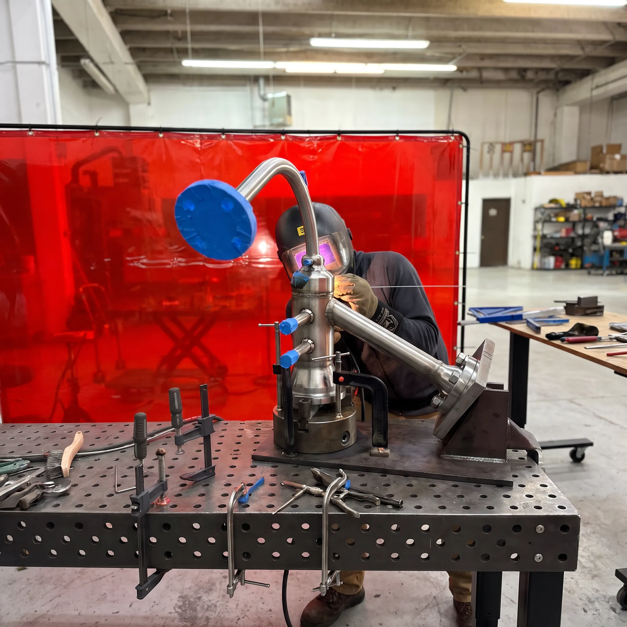 Welder performing precision TIG welding on a specialty metal assembly