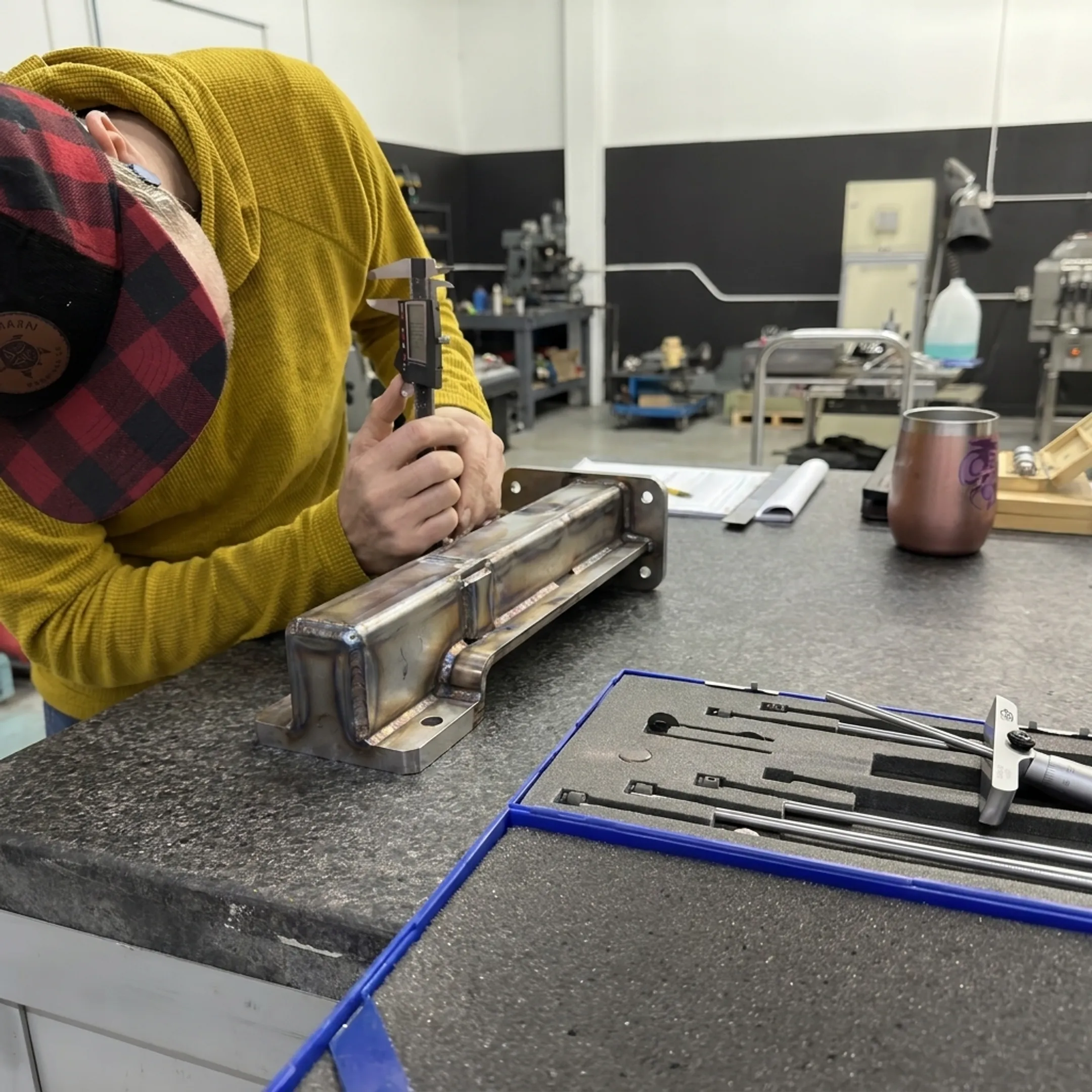 Fabricator inspecting a completed precision metal assembly