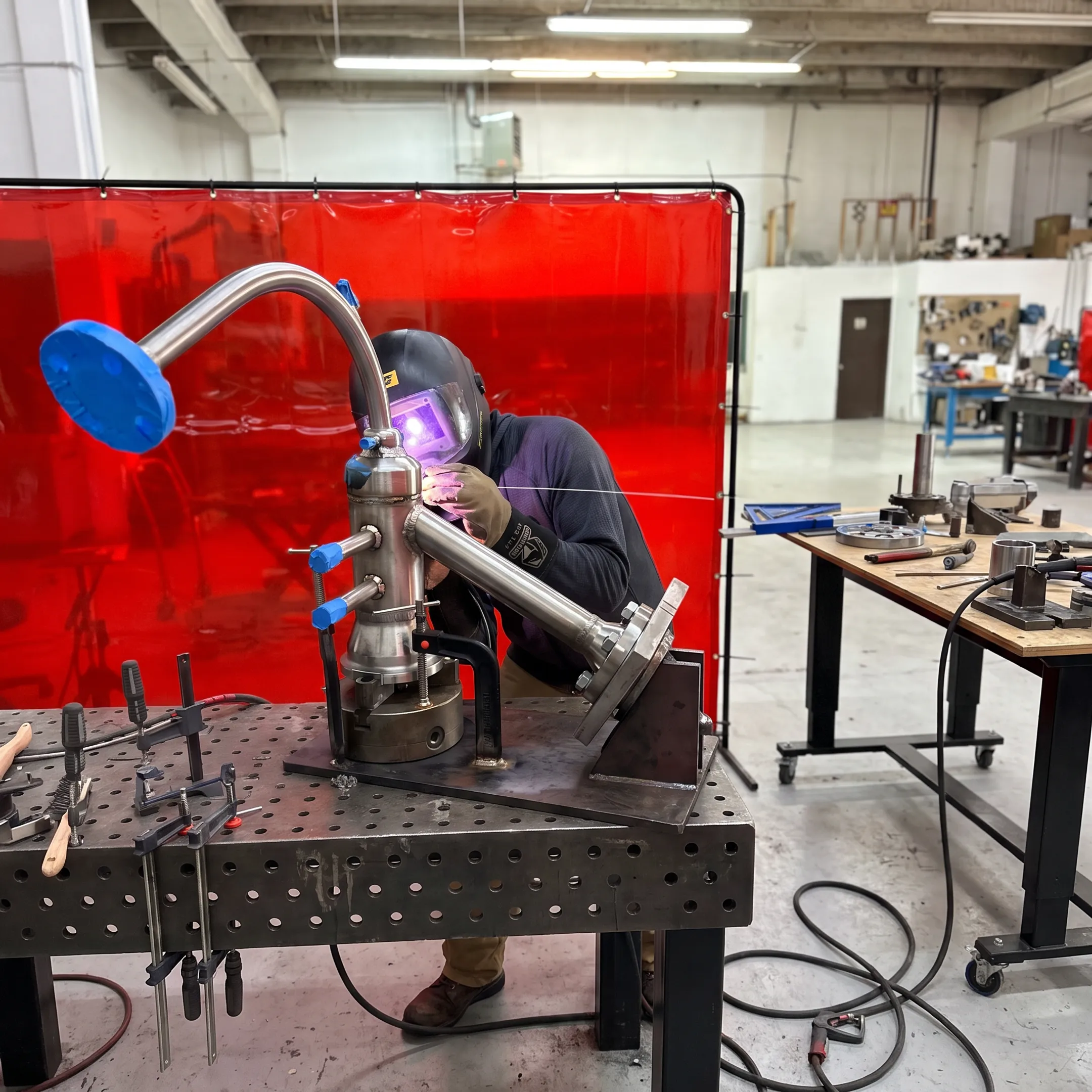 Welder fabricating a precision metal assembly in a professional shop