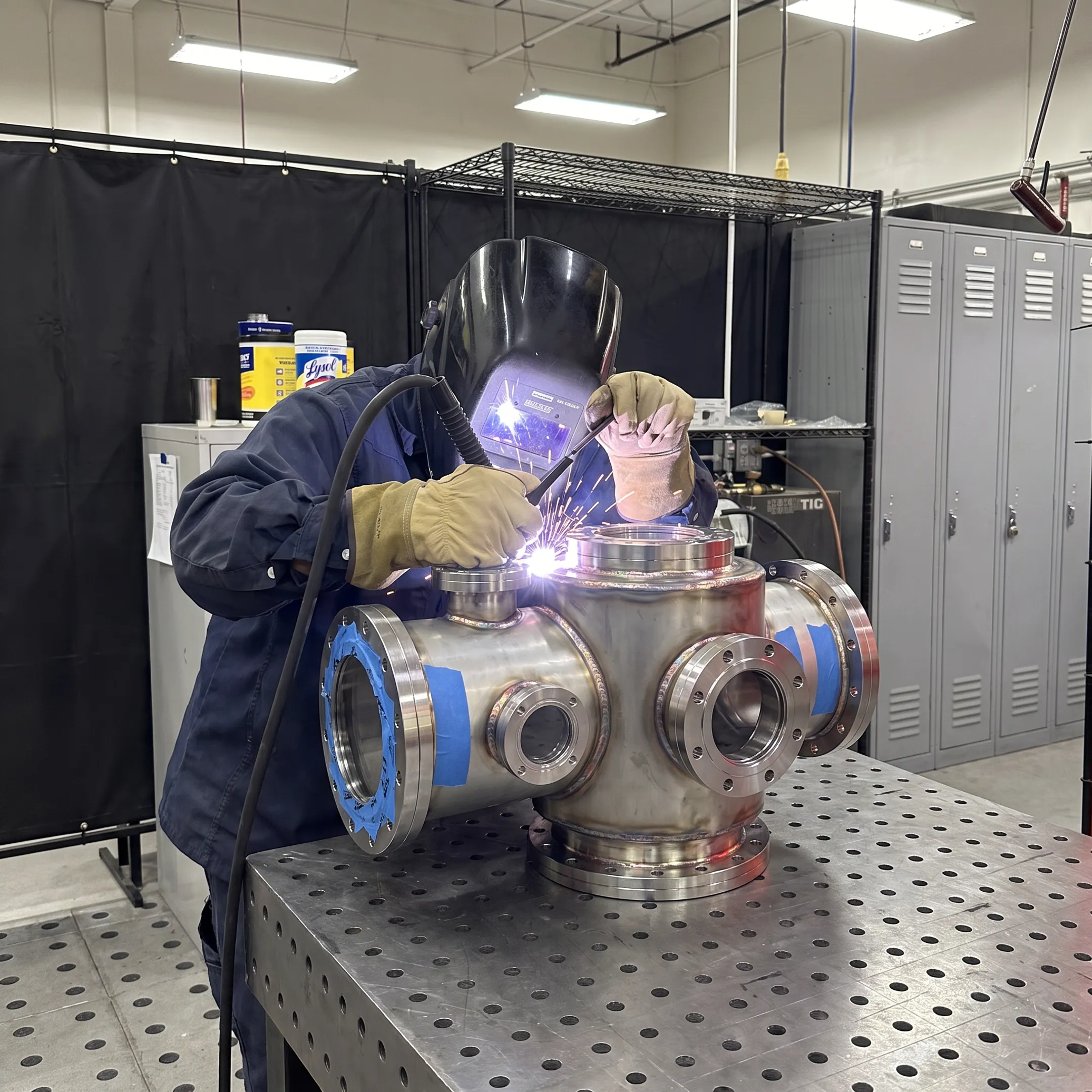 Custom vacuum chamber being precision welded in a fabrication workshop